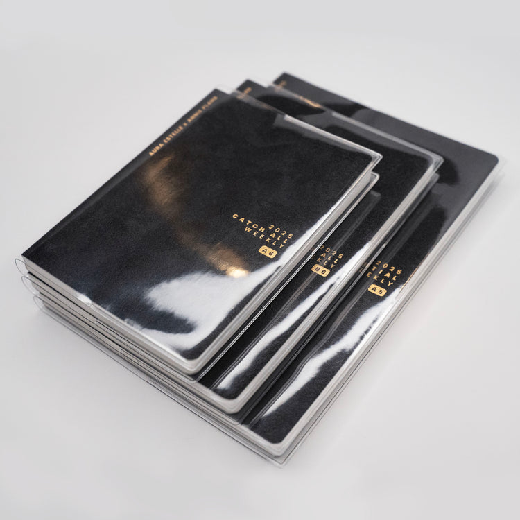 Aura Estelle clear planner covers stacked on black planners