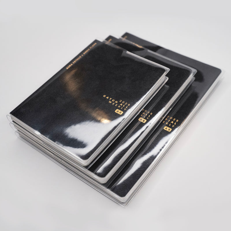 Aura Estelle clear planner covers stacked on black planners