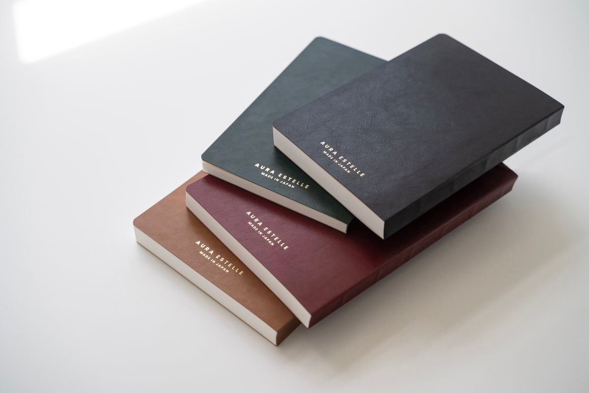 Stack of Aura Estelle magnet planners seen from the side, showing the thickness of each layout