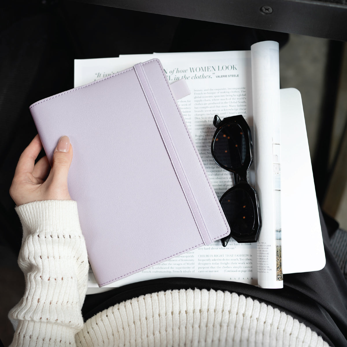 Lilac B6 SKIN planner cover held over a magazine with sunglasses